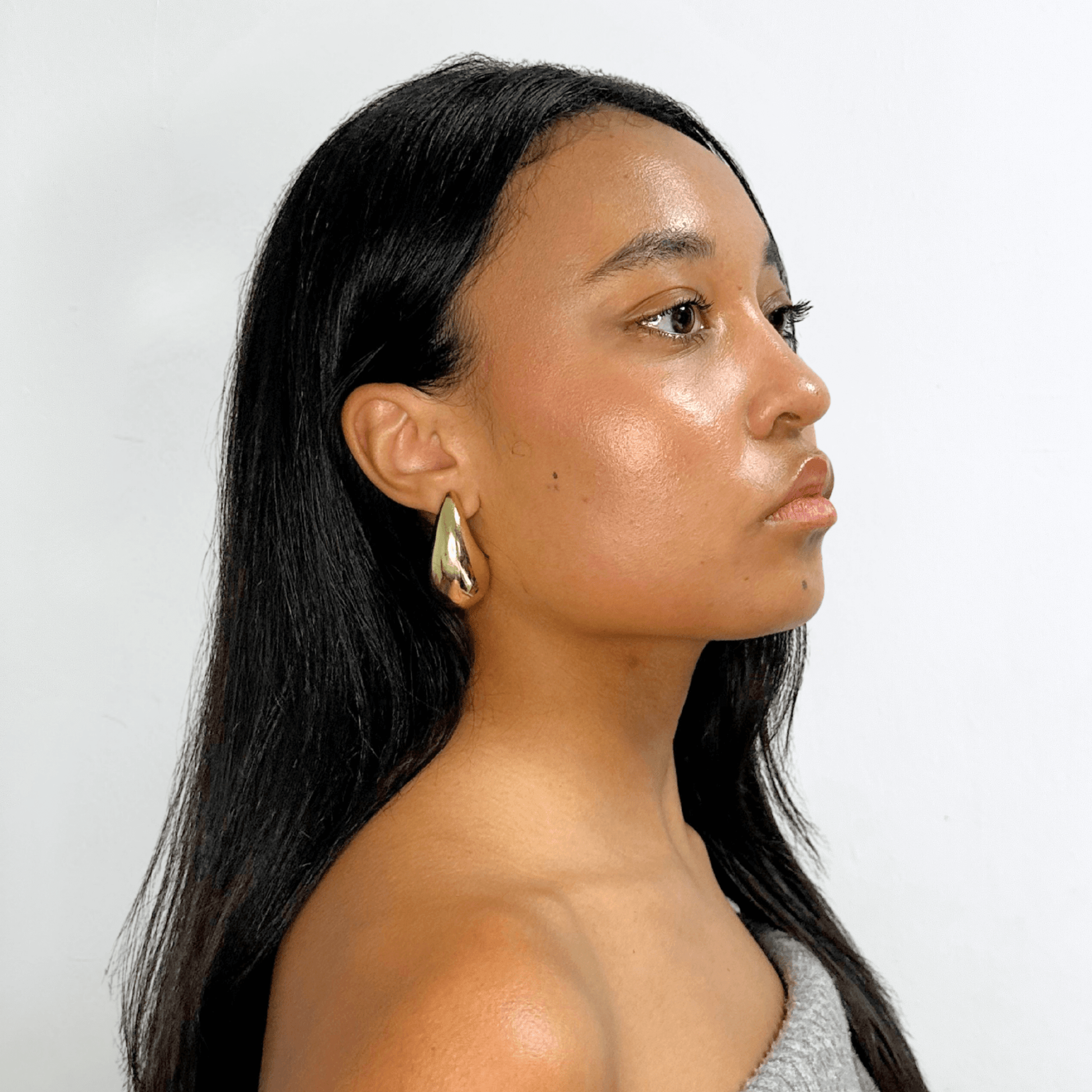 Side profile of woman wearing Alvéra Gold Bold Waterdrop Stud Earrings – gold-plated elegant statement studs, trending minimalist earrings for women