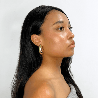 Side profile of woman wearing Alvéra Gold Bold Waterdrop Stud Earrings – gold-plated elegant statement studs, trending minimalist earrings for women